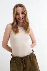 Musculosa en tejido rib color beige, de corte ajustado y cuello redondo.