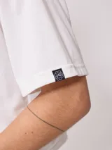 Remera blanca de algodón con calce holgado y largo cropped. Estampado frontal con el logo de la marca Rusty en óvalo con borde rosa y celeste.