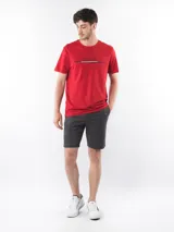 Bermuda gris de corte chino, con bolsillos laterales y traseros, cierre con cremallera y botón, trabillas para cinturón y logo de Calvin Klein bordado en la parte trasera.