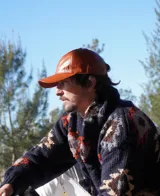 Gorra de cuero color camel con visera curva y ajuste trasero con hebilla metálica.