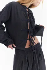 Blusa de denim liviano, estilo oriental con cierre frontal de lazos y costuras a contratono.