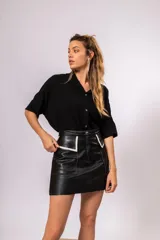 Camisa oversize de manga corta, color negro, con cuello mao y cierre frontal de botones dorados.