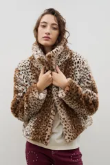 Campera corta de piel sintética en color crema, con cuello amplio tipo solapa y cierre frontal.