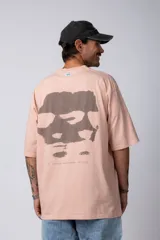 Remera blanca de corte oversize con cuello redondo y mangas cortas. Presenta un pequeño estampado tipográfico en la parte inferior frontal y un diseño gráfico de mayor tamaño en la espalda.