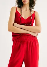 Pantalón de lino color rojo, de corte holgado y talle alto con cintura elástica fruncida. Presenta diseño recto que se estrecha ligeramente hacia los tobillos.