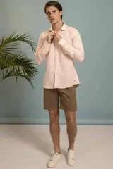 Camisa de manga larga en color salmón con estampado de pequeños motivos geométricos oscuros, cuello clásico y cierre frontal con botones.