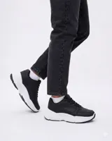 Championes urbanos de diseño moderno, color negro con suela de plataforma blanca. Presentan cordones al tono y una estructura robusta con acabado en cuero sintético.
