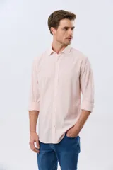 Camisa de lino a rayas finas en tonos beige y blanco, de manga larga con puños vueltos, cuello camisero y cierre frontal de botones. Cuenta con un pequeño logo bordado en el pecho.