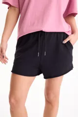 Short deportivo sin friza color beige, con cintura elástica con cordón ajustable, bolsillos laterales y terminaciones deshilachadas.