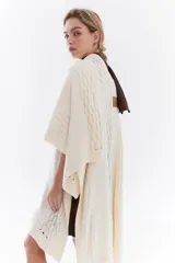 Ruana de punto color beige con detalles texturizados y tramados abiertos, ligera y versátil.