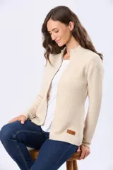 Campera tejida de abrigo color beige, con cierre frontal, cuello alto y bolsillos laterales.