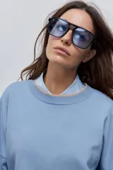 Sweater tejido celeste de calce relajado con cuello redondo, hombros caídos y puños y ruedo acanalados con detalles en tono tostado.