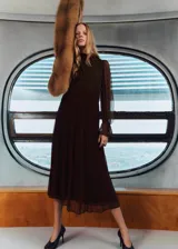 Vestido midi de gasa color marrón chocolate, con cuello alto, mangas largas abullonadas con puños ajustados y panel fruncido en la cintura. Presenta un diseño recto y fluido con forro interior.