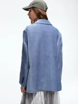 Blazer de pana color marrón con solapas clásicas, cierre frontal de dos botones y bolsillos laterales con solapa.