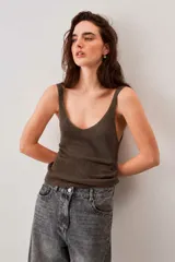 Blusa de punto color marrón chocolate con escote en V y breteles finos, de caída suave y textura tejida con sutil brillo.