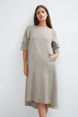 Vestido midi acampanado de lana fina sin teñir, con cuello bote, mangas tres cuartos con tajo y bolsillos laterales. Diseño forrado con vuelo y movimiento.