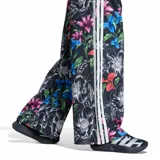Pantalón deportivo Adidas Farm Tiro de mujer, color negro con estampado floral multicolor y las clásicas tres tiras blancas a los lados. Cuenta con cintura elástica.
