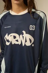 Remera de manga larga estilo deportivo, confeccionada en tejido técnico. Presenta un diseño color block en tonos bordó y rosa, con cuello mao y estampado gráfico frontal en color blanco.