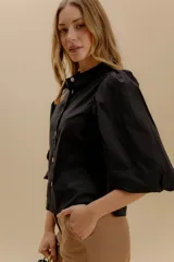 Camisa a rayas verticales rojas y blancas, con cuello bebé, mangas globo 3/4 y botones nacarados.