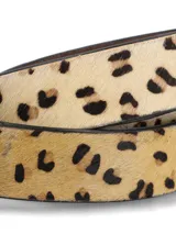 Cinturón de cuero natural con textura de pelo y estampado animal print. Presenta una hebilla metálica ovalada en tono plata envejecida y siete agujeros para ajuste.