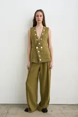Chaleco de lino color verde militar, con escote en V profundo, sin mangas y cierre frontal cruzado con doble botonadura de nácar.