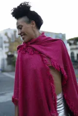 Chall de tejido liviano de algodón color fucsia, con flecos en los bordes y caída fluida.