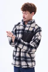 Campera de sherpa con diseño a cuadros en tonos marrón y azul marino. Presenta cuello alto, cierre frontal parcial y un bolsillo frontal con cierre en contraste de color azul marino.