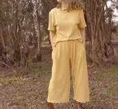 Pantalón color verde claro, de corte ancho y largo ¾, con cintura elastizada y bolsillos laterales.