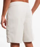 Bermuda de hombre estilo surf, color beige, con cintura fija, cordón contrastante y bolsillo trasero con tirador.