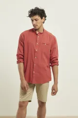 Camisa de cuello mao y manga larga, confeccionada en una mezcla de lino y algodón. Presenta un diseño de corte recto con botones en tono natural y un bolsillo pequeño en el pecho.