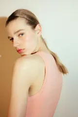 Top de punto color crema, sin mangas, con cuello redondo y corte ajustado.