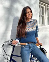 Sweater azul con cuello redondo y diseño geométrico en tonos beige, blanco y azul en la parte superior. Tejido de punto grueso.