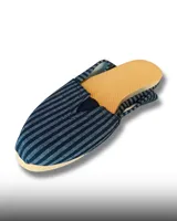 Alpargata de tela con diseño de rayas verticales en blanco y negro, con suela de goma color naranja y detalle elástico en el empeine.