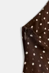 Vestido mini de cuello halter con diseño de volantes escalonados. Presenta estampado de lunares, cierre lateral con cremallera oculta y lazada ajustable en el cuello.