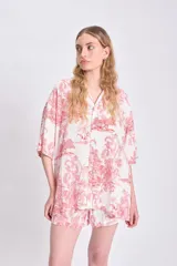 Camisa de manga corta oversize de lino con estampado de palmeras y animales en color rojo sobre fondo blanco.