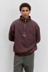 Buzo de cuello alto con cierre frontal parcial, de corte holgado y diseño minimalista con pequeño estampado central en el pecho.