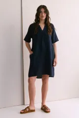 Vestido corto color arena de lino, con cuello en V y mangas cortas.