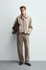 Cazadora de corte relajado confeccionada en tejido compacto de algodón. Presenta cuello solapa, cierre frontal con cremallera, mangas largas y bolsillos laterales de vivo. El bajo cuenta con acabado elástico en la espalda.