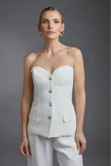 Corset negro con escote corazón, sin mangas y con tres botones dorados.