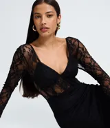 Vestido midi de encaje negro con mangas largas, escote en V estructurado y detalle de recorte tipo corset en el torso. La falda presenta un diseño con transparencia y caída fluida.