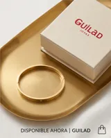 Pulsera tipo esclava rígida de acero con baño de oro, decorada con circonias incrustadas a lo largo de toda la pieza.