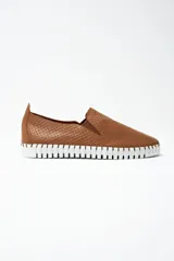 Zapatilla tipo slip-on de cuero color tostado, con textura perforada y suela de goma blanca con diseño dentado.