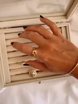 Anillo de acero quirúrgico en color dorado, con diseño trenzado y estructura ajustable.