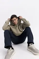 Canguro con capucha de calce oversize, color azul grisáceo. Presenta un estampado gráfico en la espalda con la inscripción 'UNDERRATED vision' y el logo de la marca Mistral. Confeccionado en tejido de algodón y poliéster.