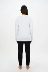 Remera de manga larga color blanco, con cuello redondo y estampa frontal artística que presenta siluetas de gatos con texturas de leopardo y tonos tierra.