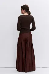 Pantalon de vestir color marron, de corte ancho y tiro alto, con diseño plisado y detalles de bolsillos frontales con botones.