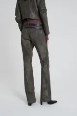 Pantalón de cuero color gris con tiro bajo, bolsillos delanteros con labio y cierre metálico oculto, pierna con recortes en delantero y pinza en espalda.