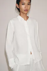 Camisa de lino de corte clásico con cuello solapa, manga larga con puños anchos y cierre frontal con botones.