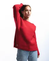 Sweater rojo de lana merino con cuello barco y motivo calado en el lateral.