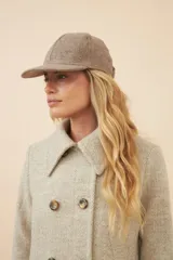 Gorra con visera confeccionada en lana fina sin teñir, con textura jaspeada en tonos tierra.